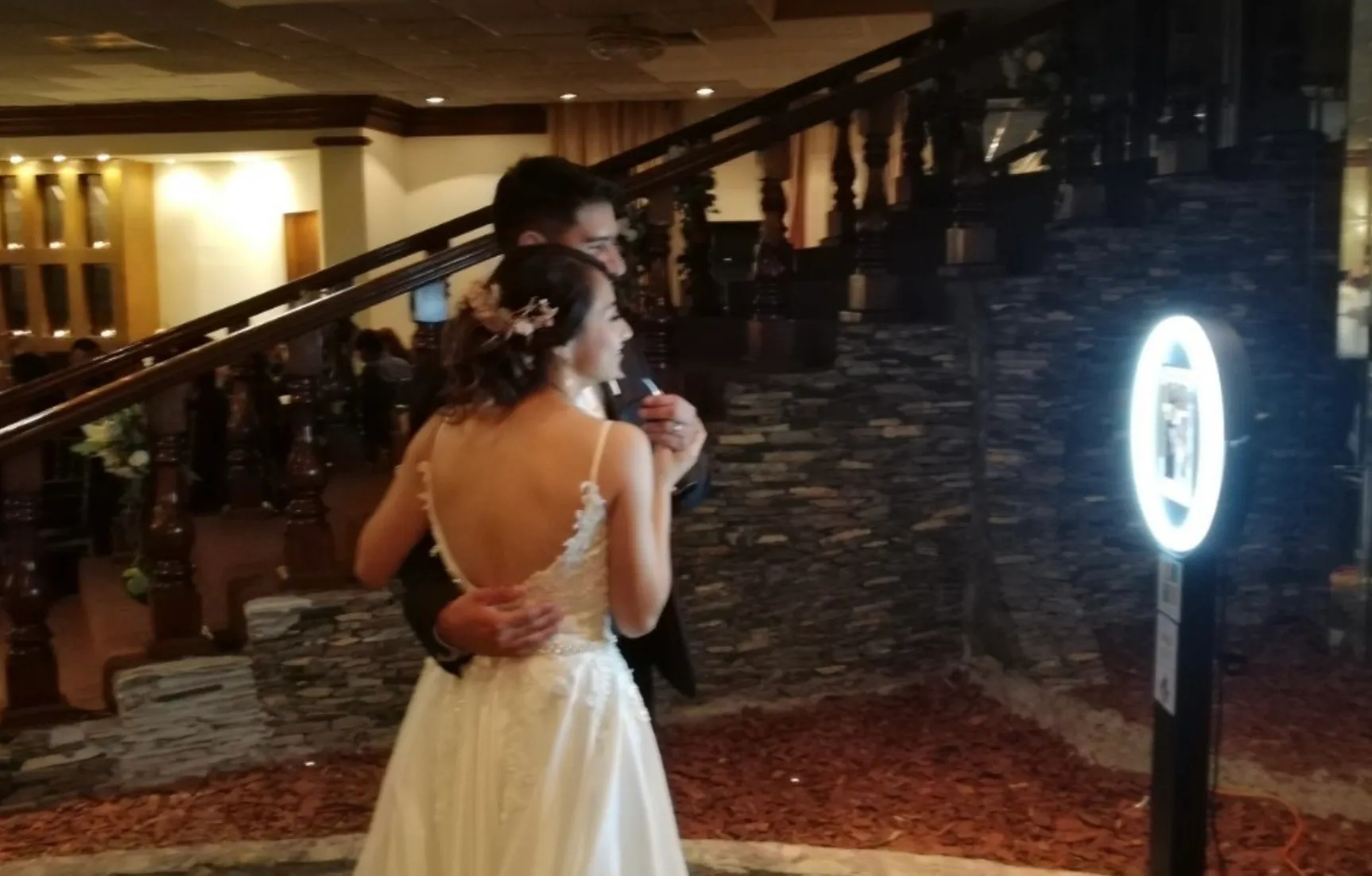 Bride and groom using video guestbook at elegant wedding venue